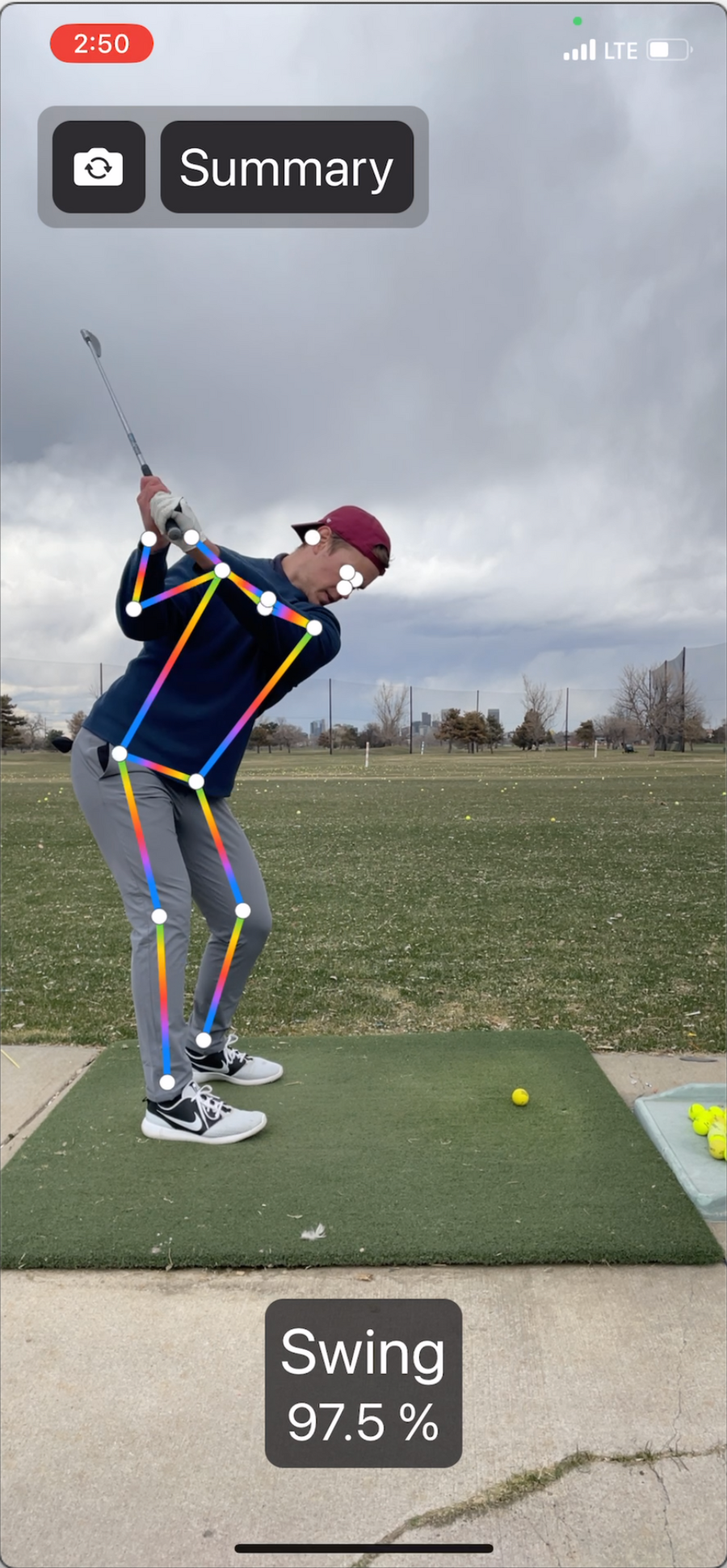 Screen capture of a golfer swinging a golf club at the driving range with a skeleton overlay generated by computer vision